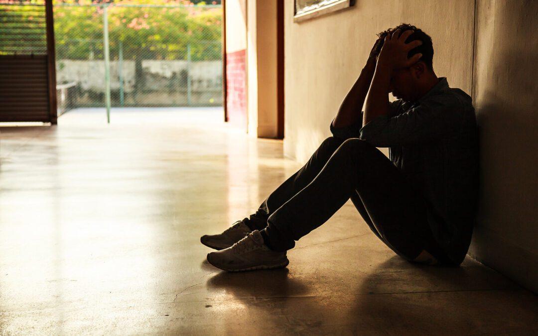 Image of a hopeless man sitting on the floor. Learn to manage and start overcoming your hopelessness with the support of adult IOP in Houston, TX.