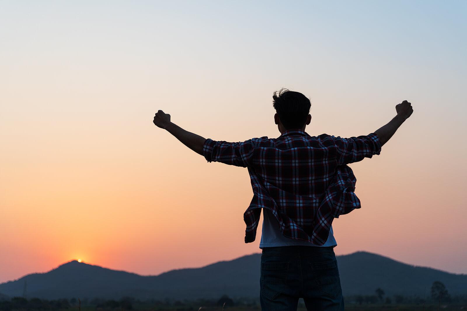 Image of a happy man standing outside raising his hands up in the air. Begin to transorm your life from surviving to thriving with the help of Adult IOP in Houston, TX.