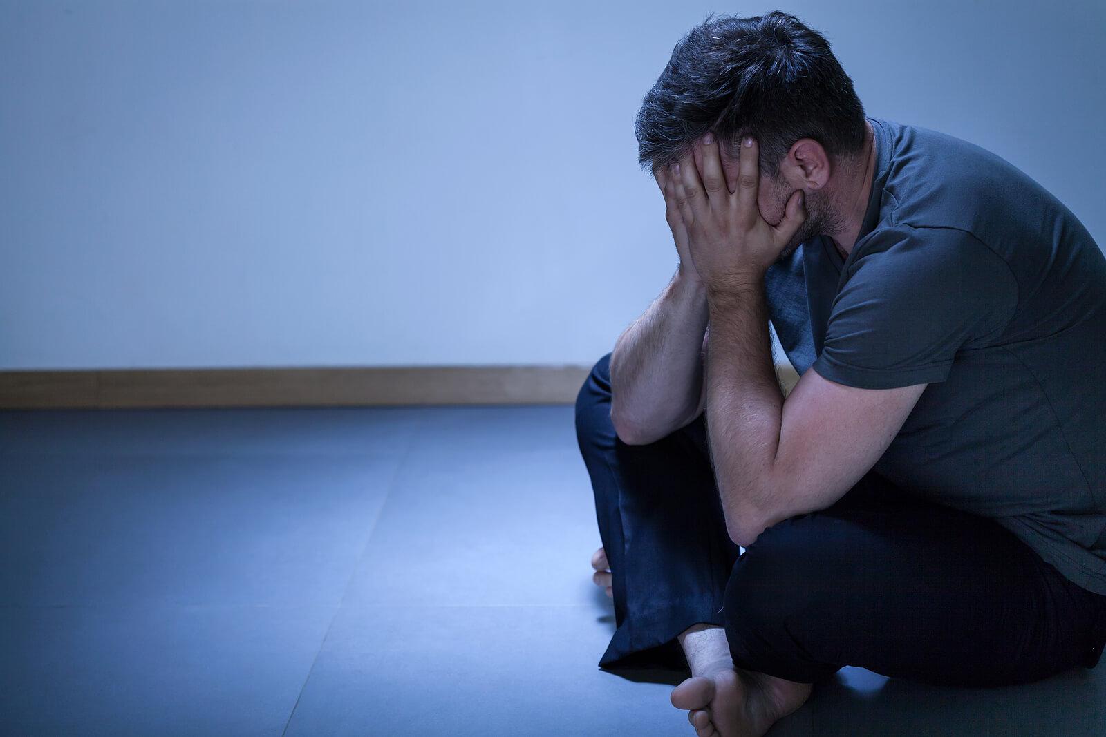 Image of a lonely depressed man sitting on the floor. If you struggle with BPD, find support with Houston Intensive Outpatient Program to begin healing from your symtpoms.