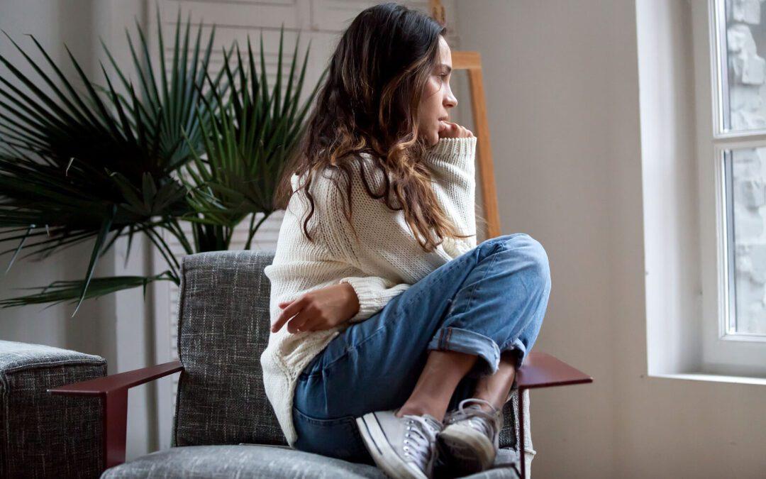 Image of a woman sitting in a chair looking out a window. If you are unable to control your emotions, discover how Adult Intensive Outpatient Program can help you control them.