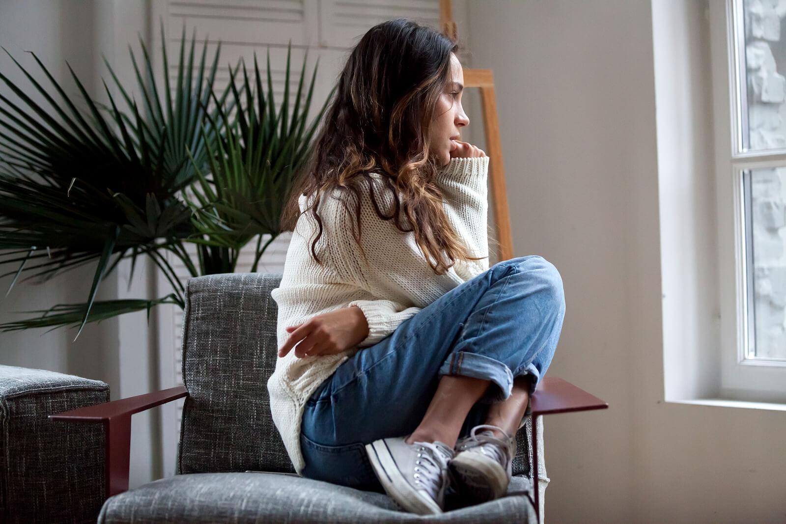 Image of a woman sitting in a chair looking out a window. If you are unable to control your emotions, discover how Adult Intensive Outpatient Program can help you control them.