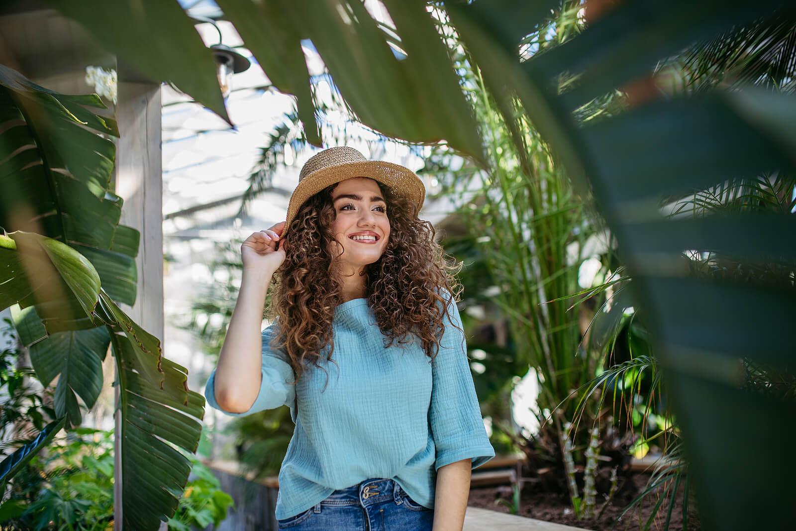 Image of a smiling young woman walking through botanical garden. Find support finding peace and healing with the help of an adult IOP in Houston, TX.