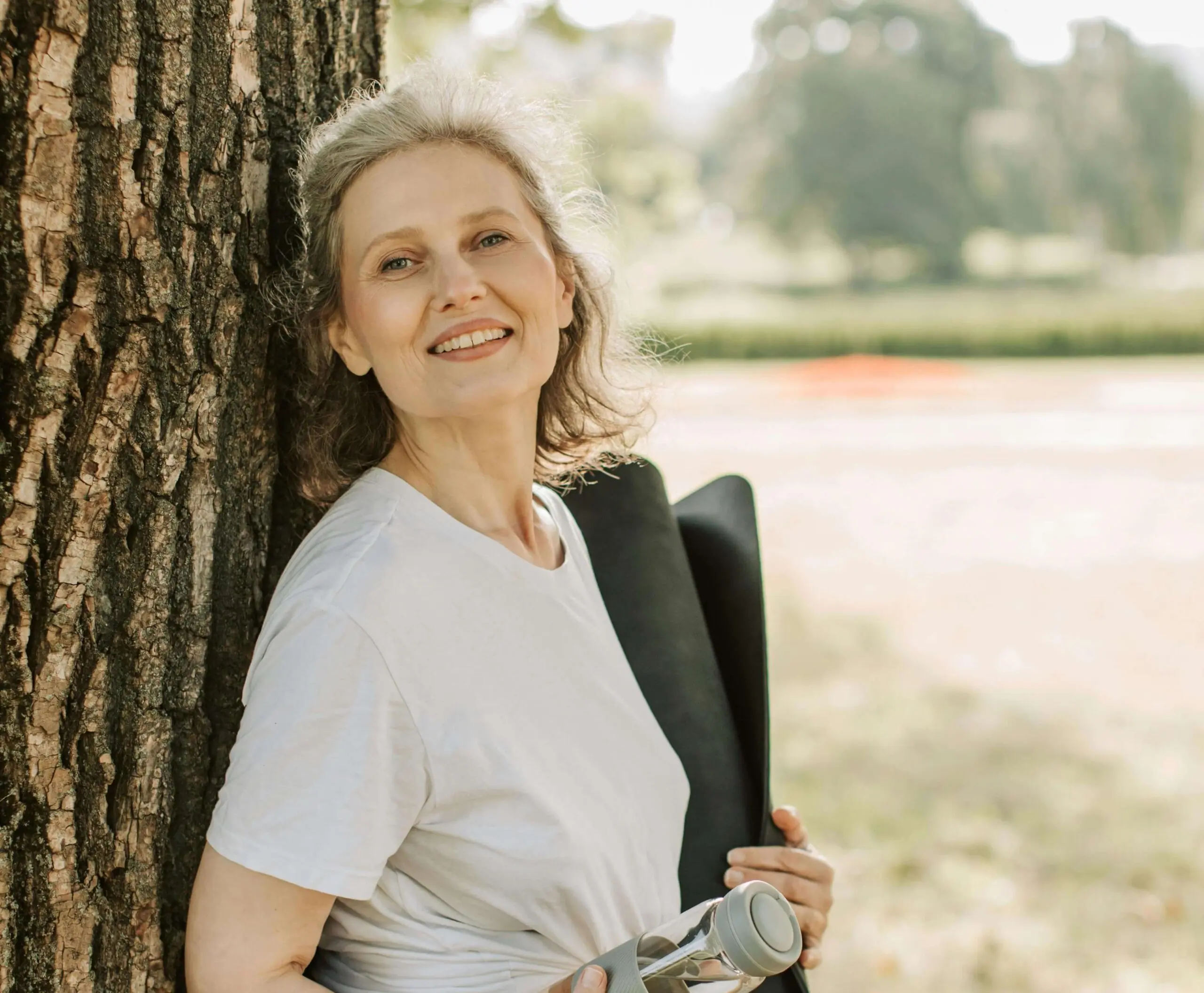 woman leaning on tree | adult iop in houston, tx | adult intensive outpatient program in houston, tx | houston iop program | adult outpatient program | 77022 | 77024 | 77057 Image of a smiling mature woman leaning against a tree. Overcome your depression and begin healing with the support of an adult intensive outpatient program in Houston, TX.