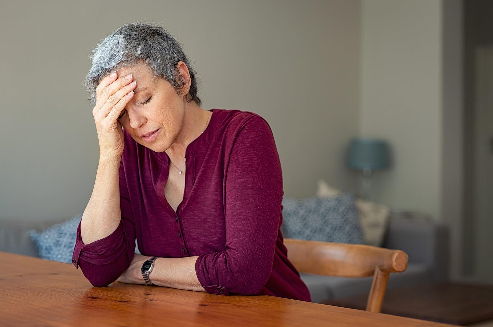 stressed mature woman | adult iop in houston, tx | adult intensive outpatient program in houston, tx | intensive outpatient program houston | adult outpatient program | 77022 | 77024 | 77057 Image of a stressed mature woman resting a hand against her face while sitting at a table. Learn to improve your decision-making skills with the support of DBT used in an Adult IOP in Houston, TX.