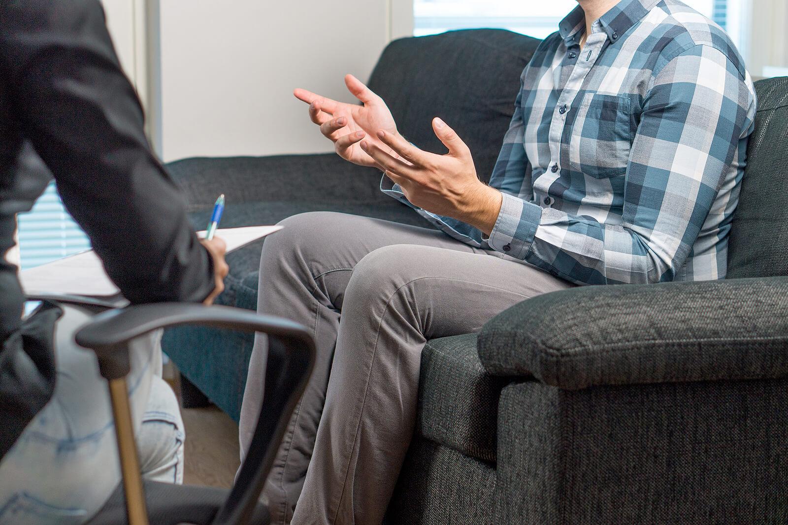 man in therapy | perfectionism treatment in houston, tx | overcoming perfectionism | perfectionism anxiety | adult iop | Montrose | Afton Oaks | Boulevard Oaks Man sitting on a couch in mental health therapy. Overcome your constant worry and break free from anxiety and self-doubt with perfectionism treatment in Houston, TX.