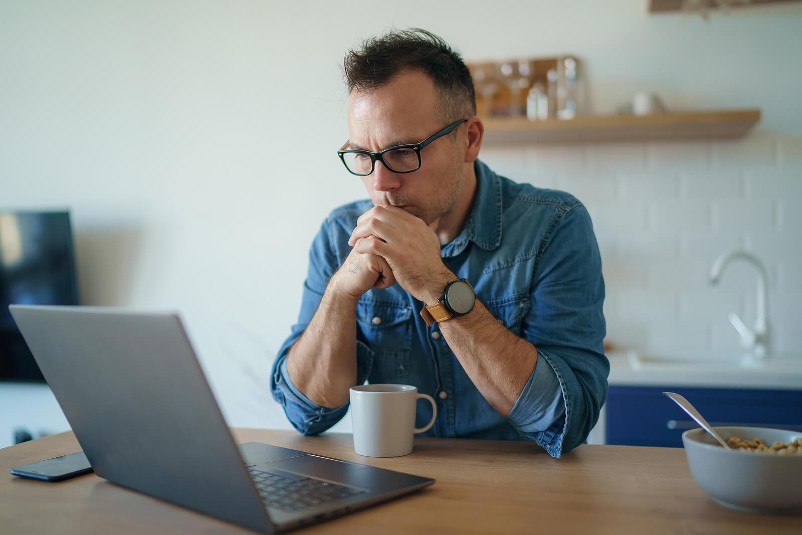 thoughtful man with laptop | perfectionism treatment in houston, tx | ocpd perfectionism | overcoming perfectionism | coping with perfectionism | Montrose | Afton Oaks | Boulevard Oaks Thoughtful man sitting at a table looking at a laptop. Don't struggle on your own with perfectionism and OCPD. With the help of perfectionism treatment in Houston, TX you can learn to reduce your anxiety in positive ways.