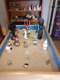 Sand tray with various miniatures sitting in the sand